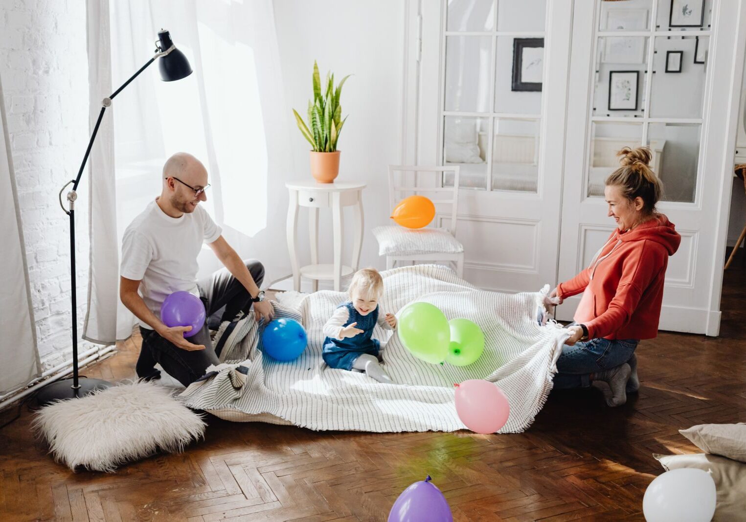 A joyful scene of a family with balloons enjoying quality time together indoors.