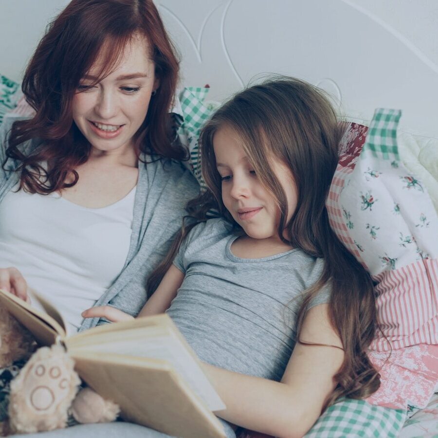 Mom and daughter read a book together.